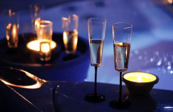 coupes de champagne au bord d'un jaccuzi durant la nuit