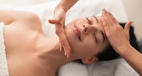 femme souriante allongée profitant d'un soin du visage
